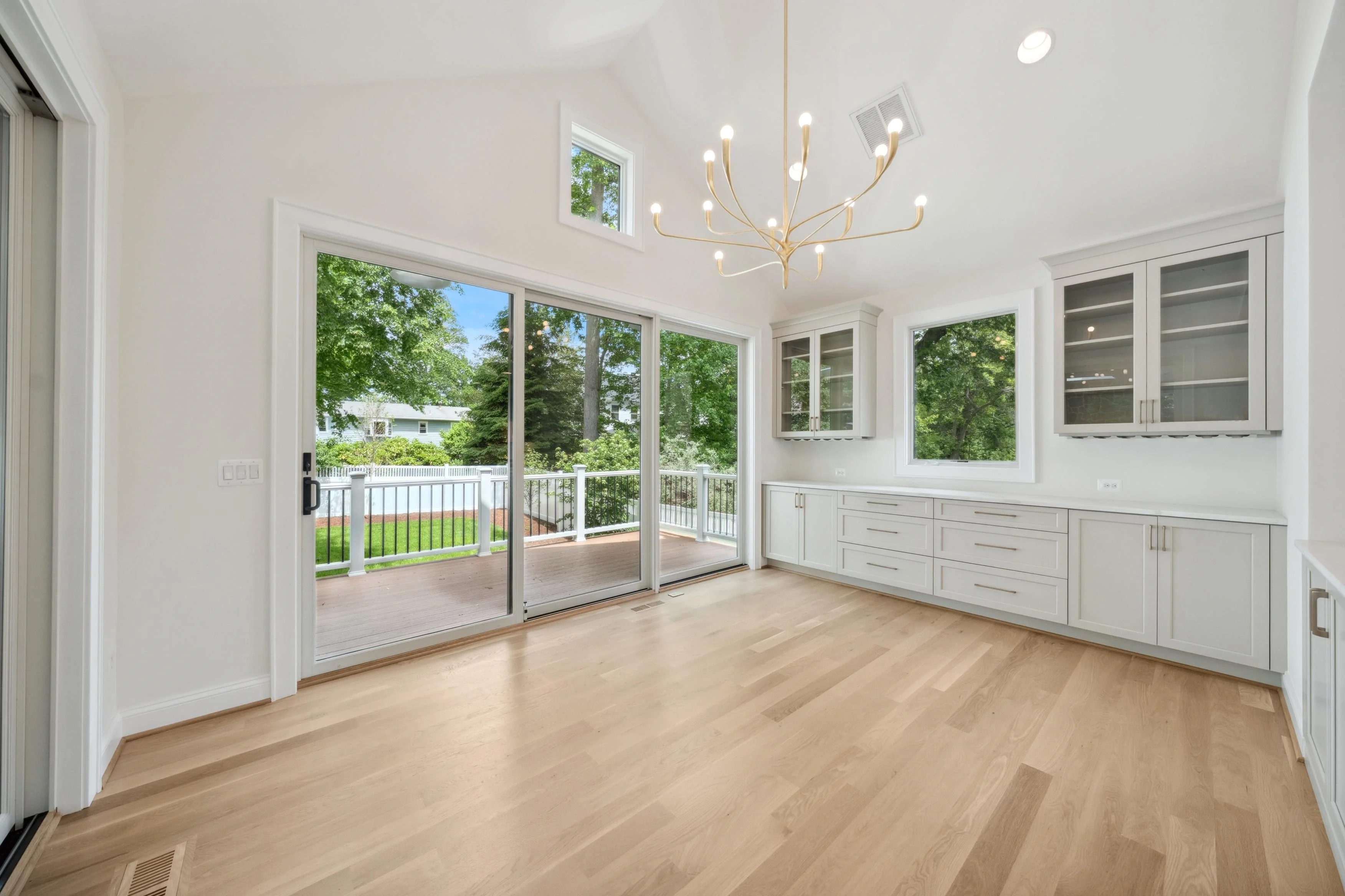 Interior real estate photography of a bright dining area with chandelier, built-in cabinetry, and garden view in Silver Spring Maryland