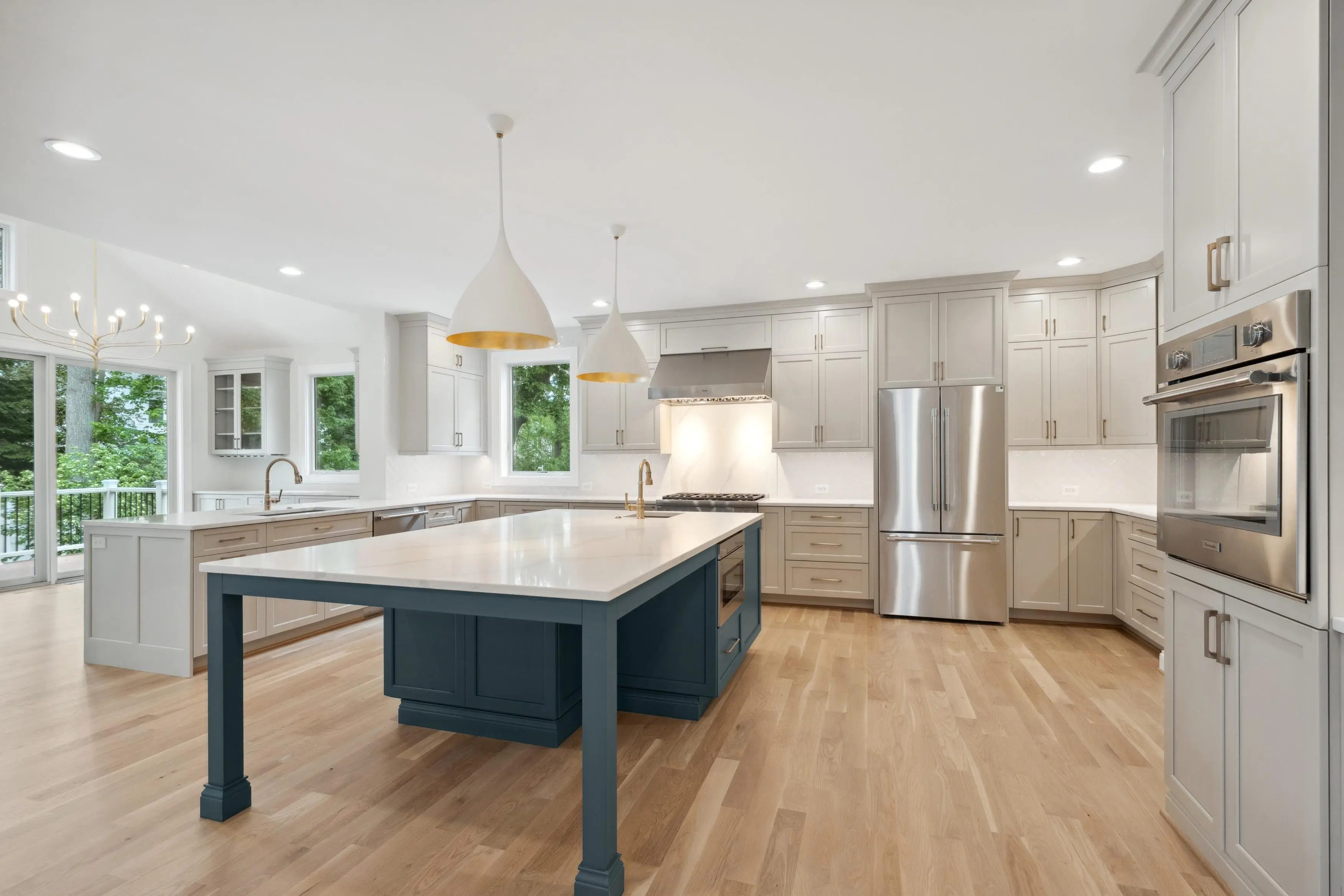 Professional HDR photography of a luxury kitchen with large island, pendant lighting, and stainless steel appliances in Potomac Maryland
