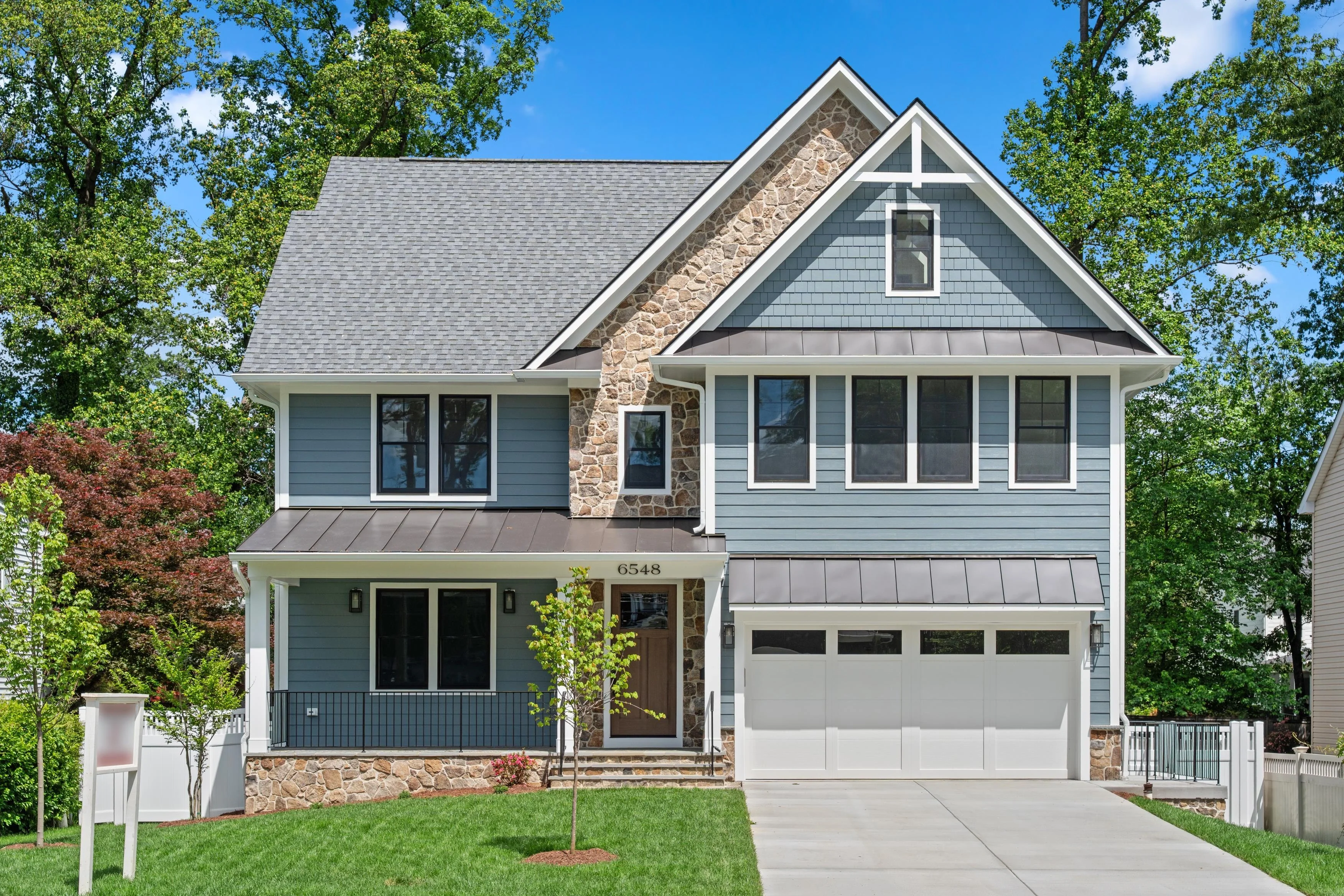 Exterior real estate photography of a modern craftsman-style home with blue siding and stone accents in Virginia