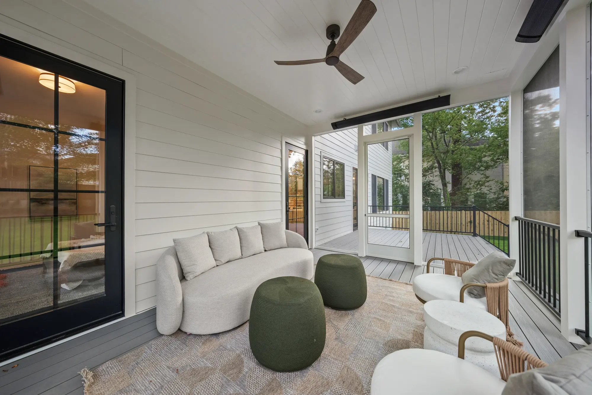 Screened-in porch lounge with modern outdoor furniture and garden views