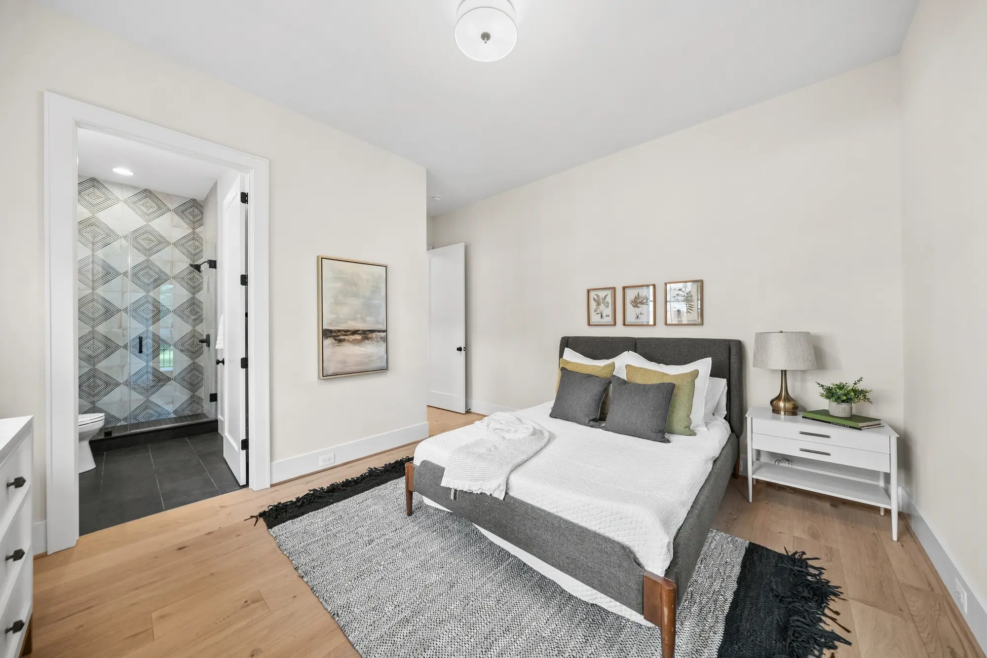 Guest bedroom with en-suite bathroom featuring geometric tile floor