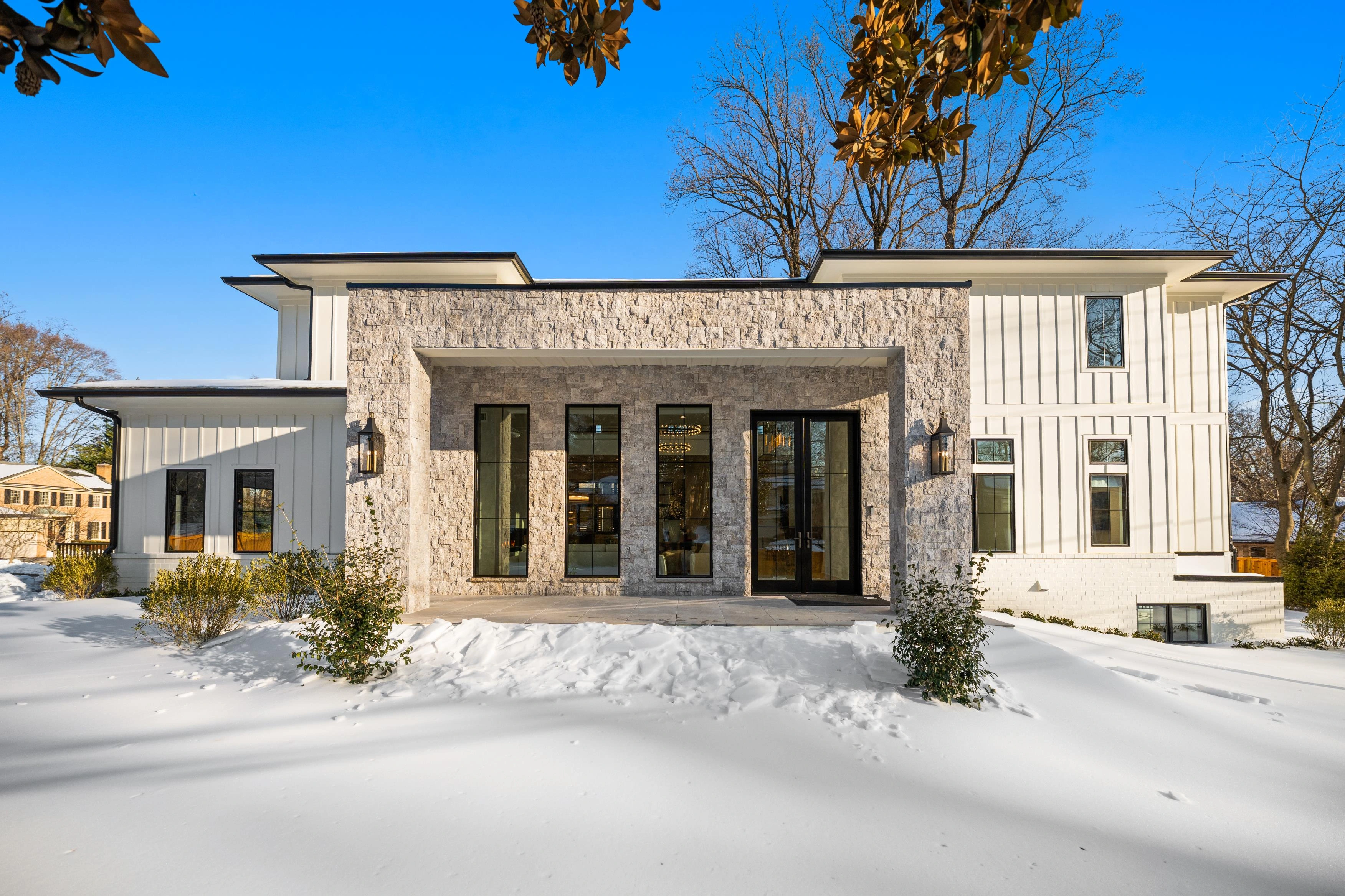 Stone and glass entry facade with modern lanterns and double-height portico