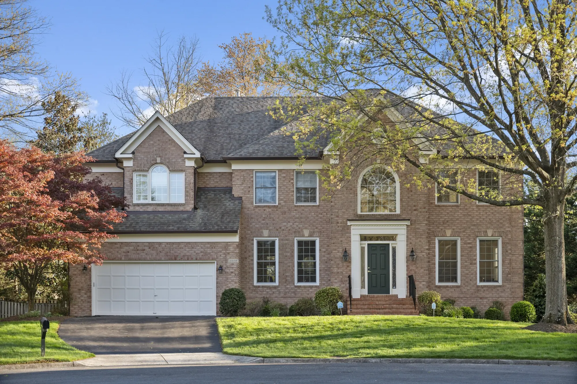 Front elevation of single-family home in Oakton VA with brick facade and manicured lawn