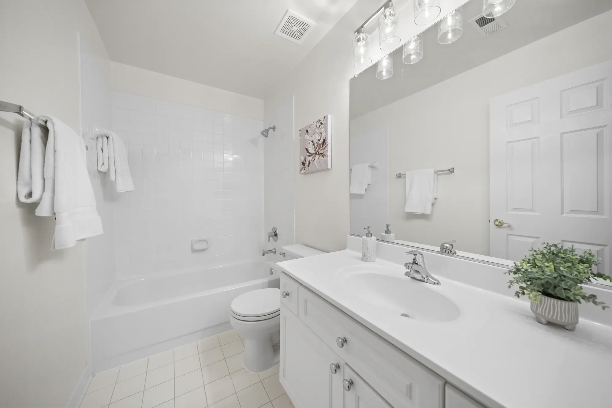 Bright guest bathroom with full bathtub and vanity