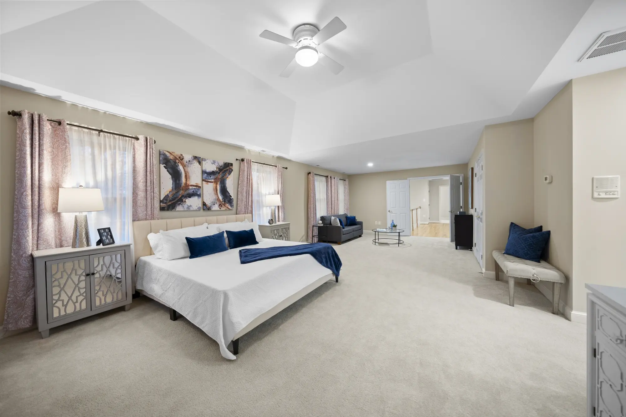 Spacious master bedroom with modern staging and natural light