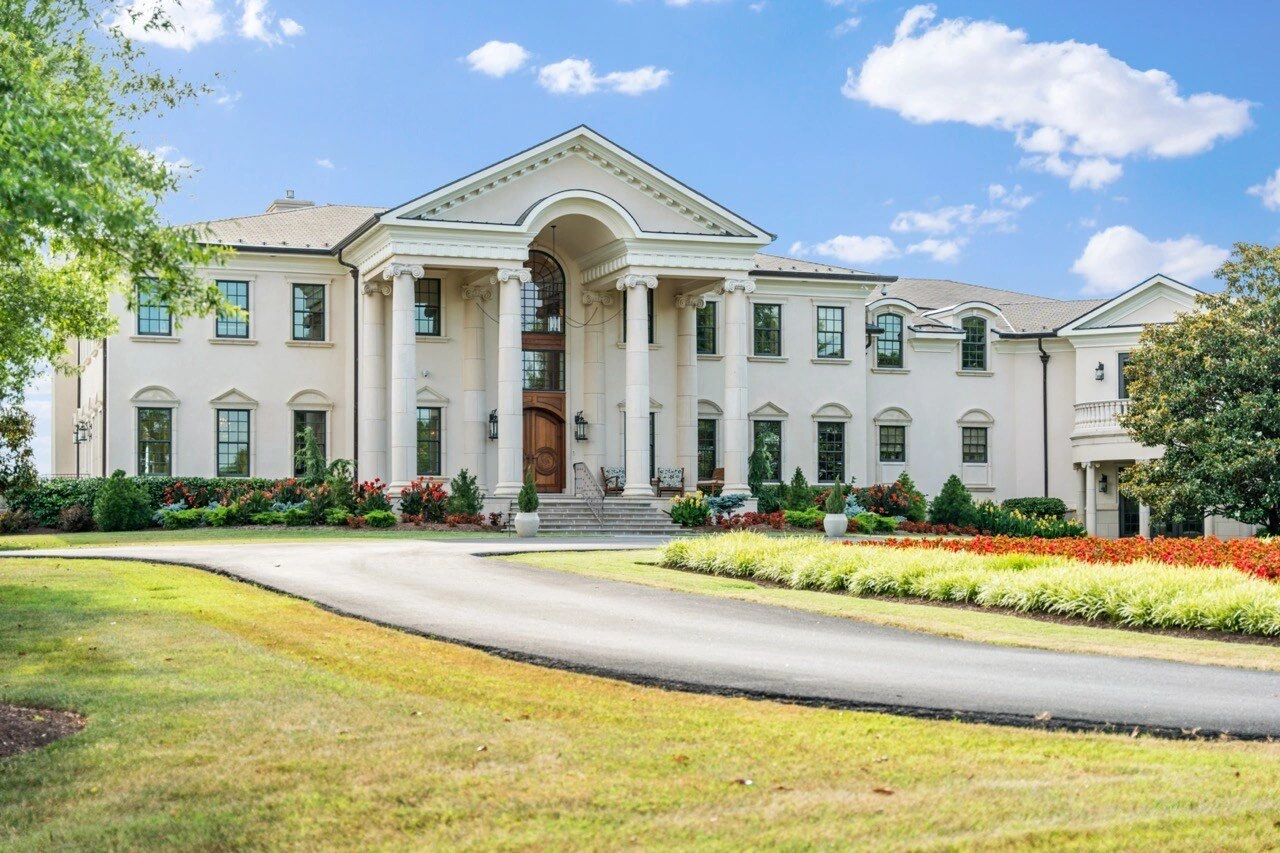 Palladian-style luxury mansion with columned portico and circular driveway