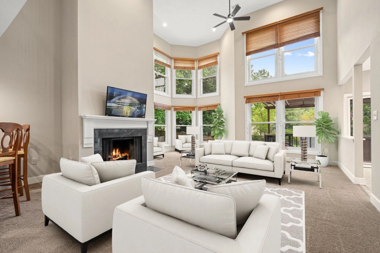 Virtual staging example — spacious living room with elegant white furniture, fireplace, and high ceilings